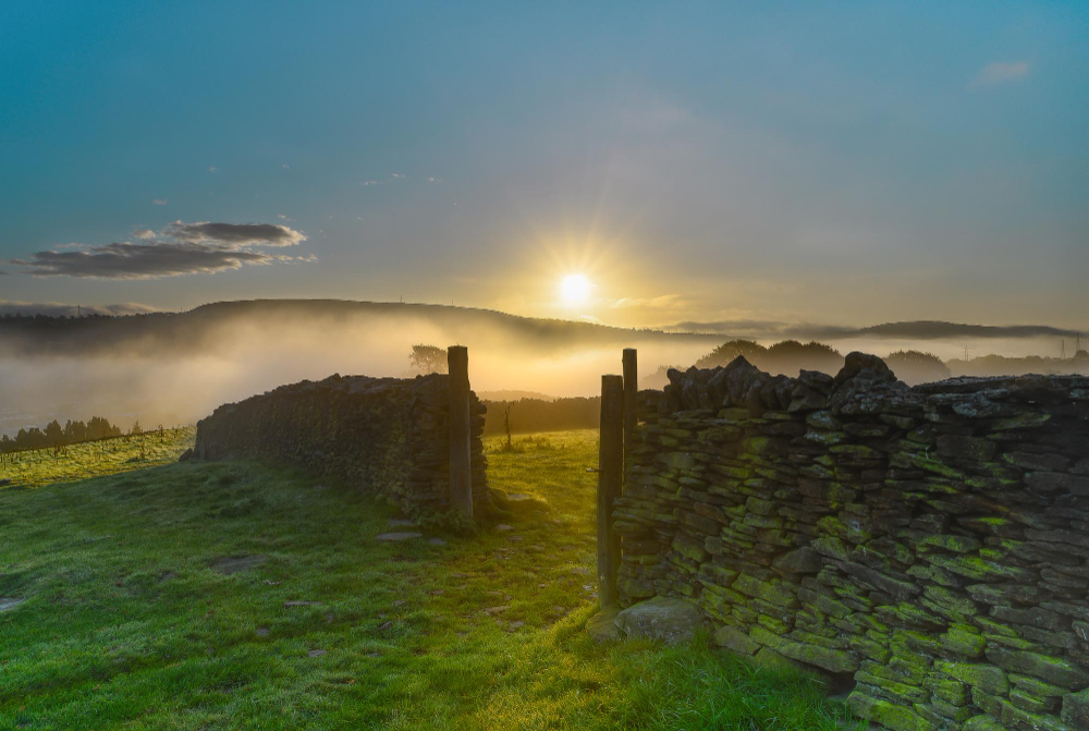 old stone wall with sunrise in the background