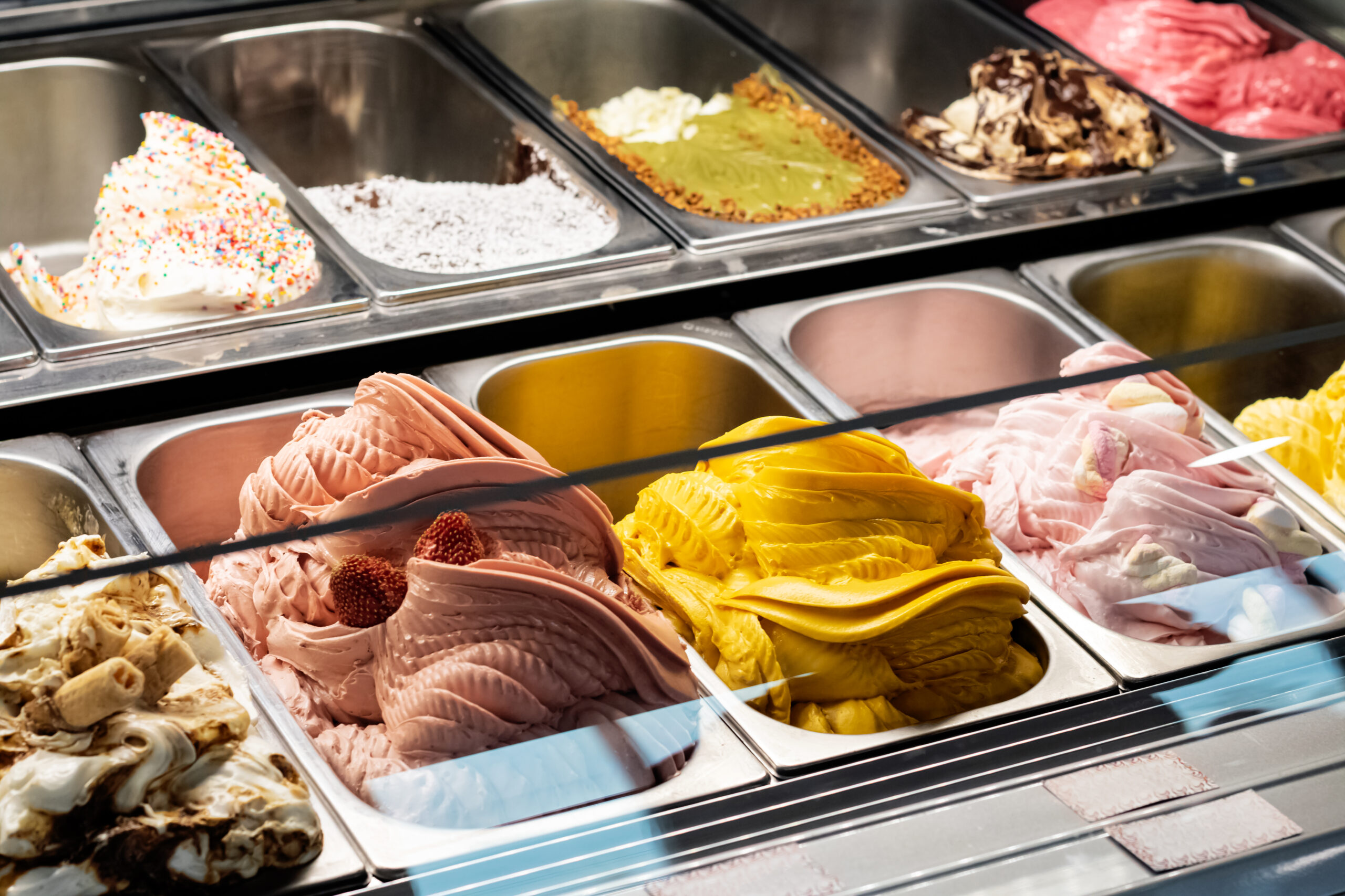 Different types of ice cream in containers on store