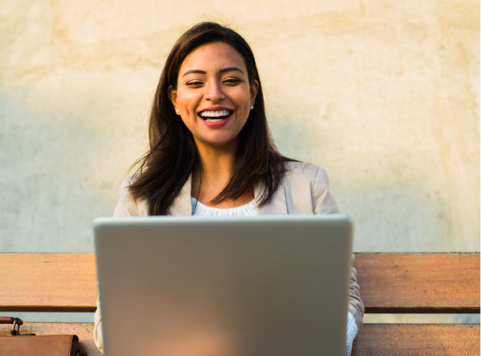 Smiling business woman looking at laptop